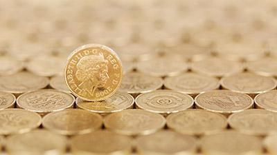 Many pound coins laid out in a neat pile