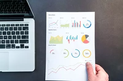 A page of generic analytic graphs next to a laptop