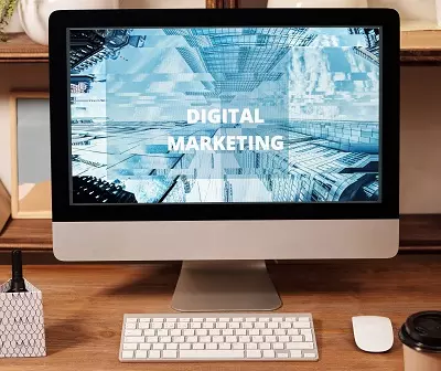 Mac with screen showing "Digital Marketing" graphic