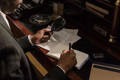 A man trying to decrypt a paper document