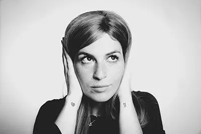 A woman holding her hands to cover her ears