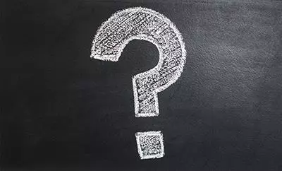 A chalk question mark on a blackboard