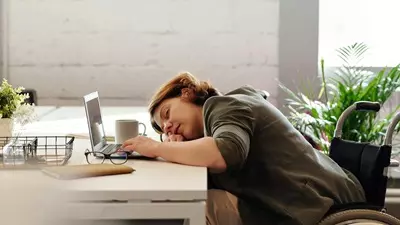 A woman asleep by her computer