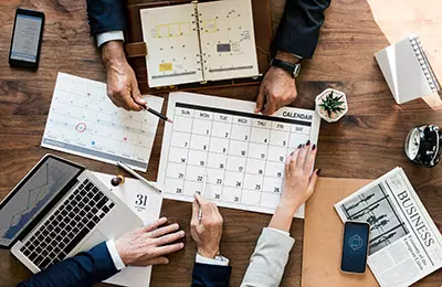 People pointing at a calendar