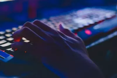 Someone typing on an illuminated computer keyboard