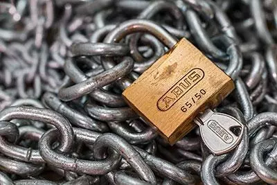 A locked padlock on a pile of chains