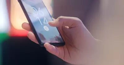 Someone unlocking their mobile with a thumb fingerprint
