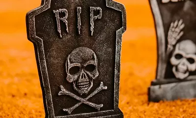 RIP on a gravestone above a skull and crossbones