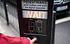 Someone pressing the button on a pedestrian crossing