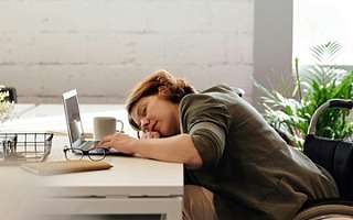 A woman asleep by her computer