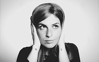 A woman holding her hands to cover her ears