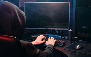 A man with a hoodie using a PC