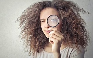 A woman looking through a magnifying glass